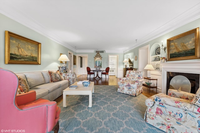 living room featuring crown molding, built in features, and hardwood / wood-style floors