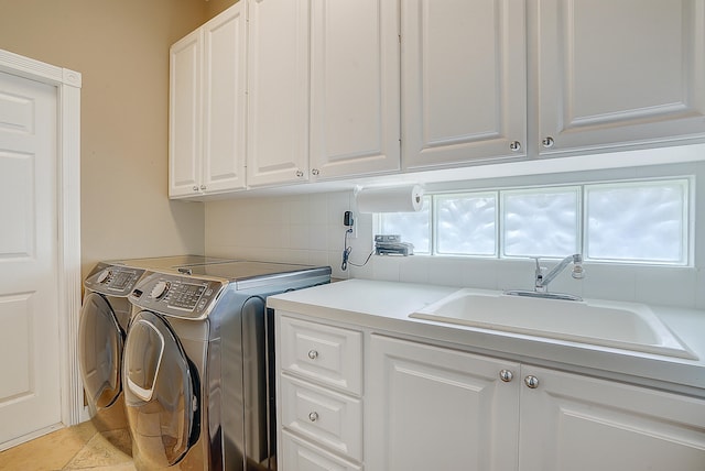 laundry room featuring independent washer and dryer, cabinets, and sink