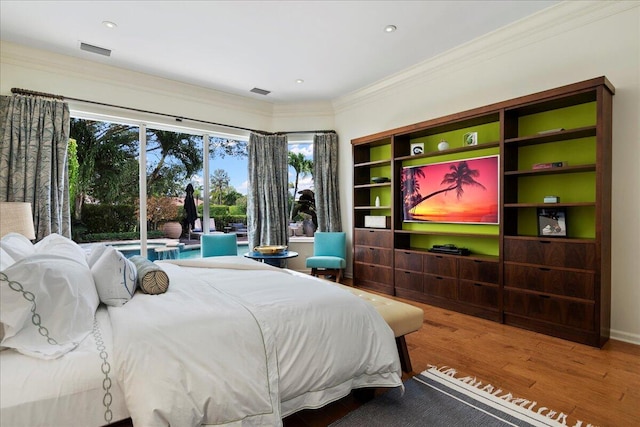 bedroom with hardwood / wood-style flooring and crown molding