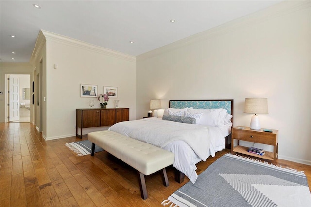 bedroom with ornamental molding and hardwood / wood-style floors