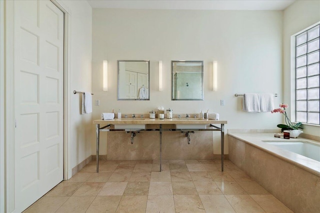 bathroom with tile floors, dual bowl vanity, and a bathing tub