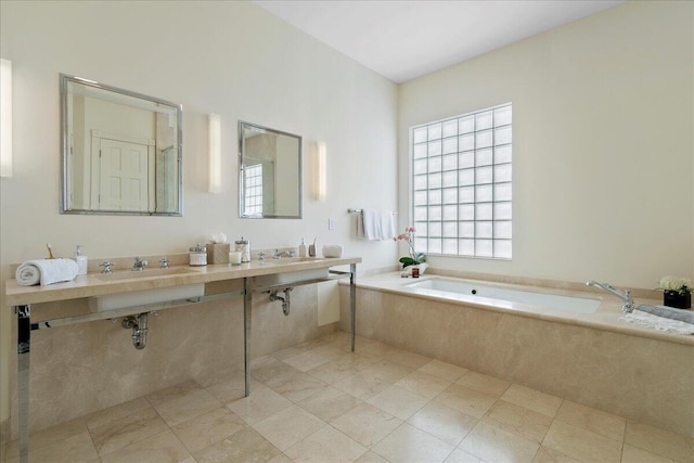 bathroom featuring sink, tiled tub, and tile floors