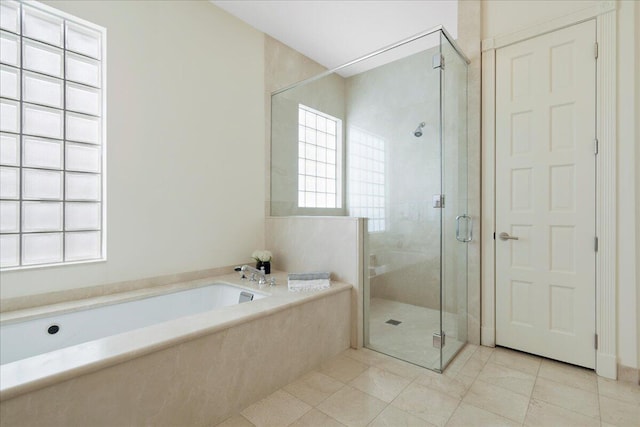 bathroom featuring a healthy amount of sunlight, tile flooring, and shower with separate bathtub