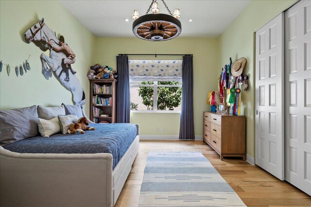 bedroom with a notable chandelier and light wood-type flooring