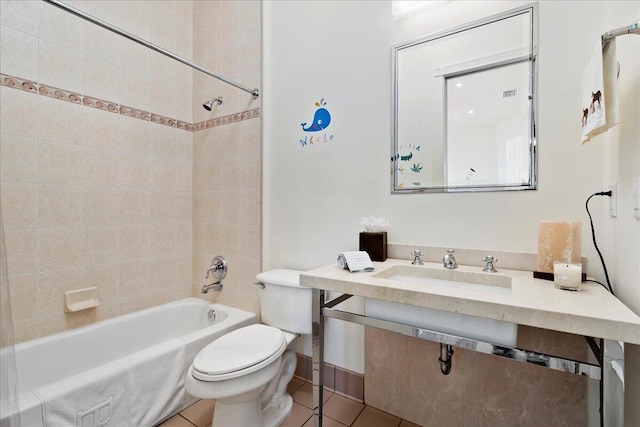 full bathroom featuring tile floors, tiled shower / bath combo, vanity, and toilet