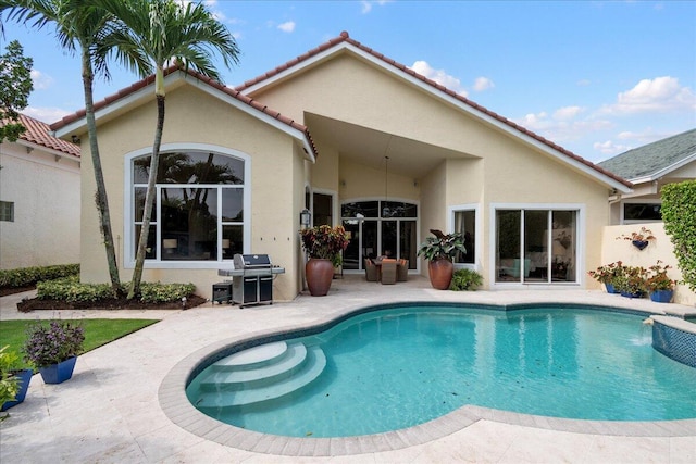 view of pool with grilling area and a patio