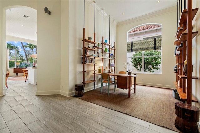 office with light hardwood / wood-style flooring and crown molding