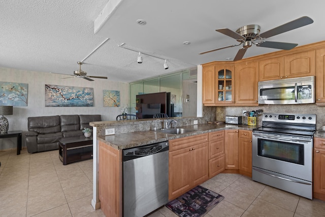 kitchen featuring a textured ceiling, kitchen peninsula, ceiling fan, and stainless steel appliances