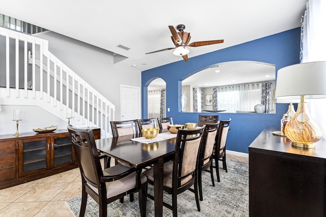 dining space with ceiling fan and light tile floors