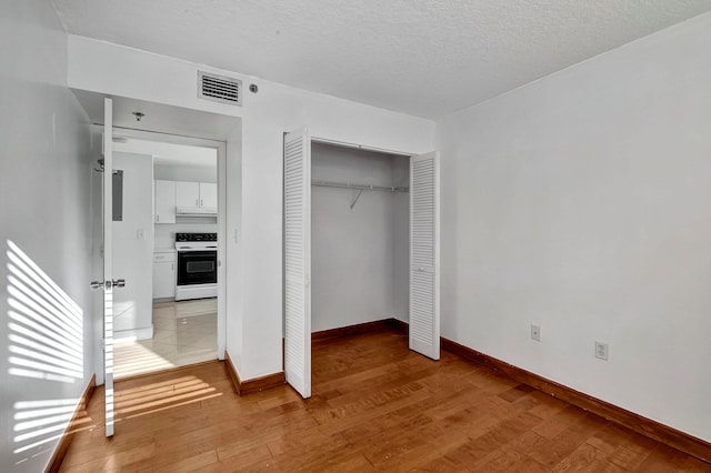 unfurnished bedroom with a textured ceiling, a closet, and light tile flooring