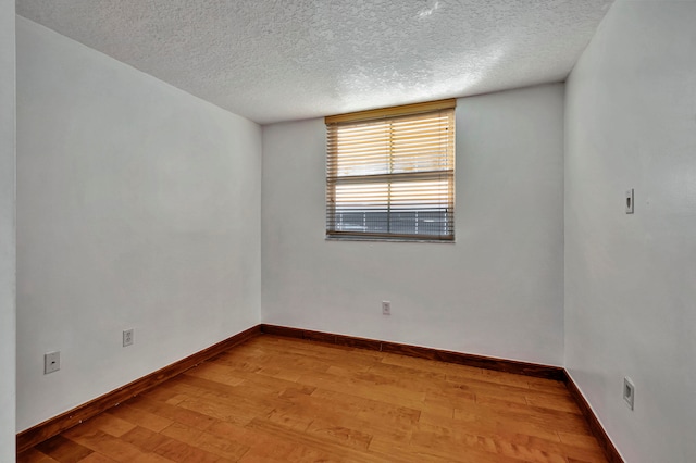 unfurnished room with a textured ceiling and hardwood / wood-style flooring