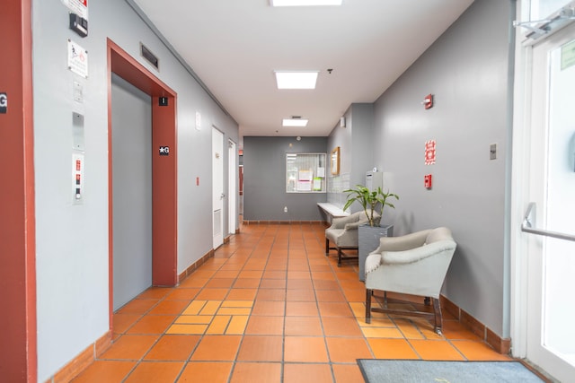 hall with tile flooring and elevator