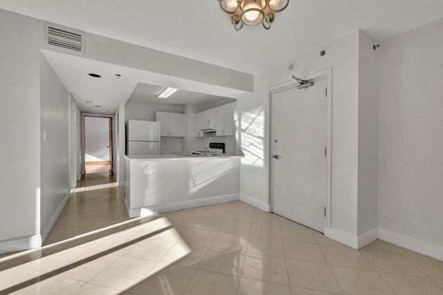 tiled foyer entrance with a chandelier