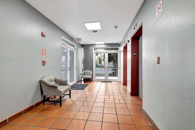 hall with french doors and light tile floors