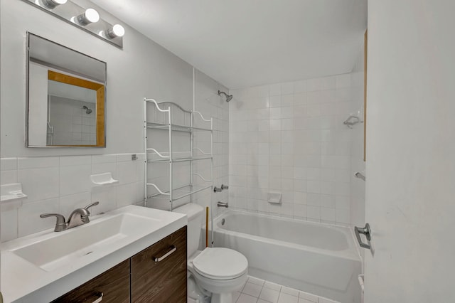 full bathroom featuring tile walls, toilet, tiled shower / bath combo, tile floors, and vanity