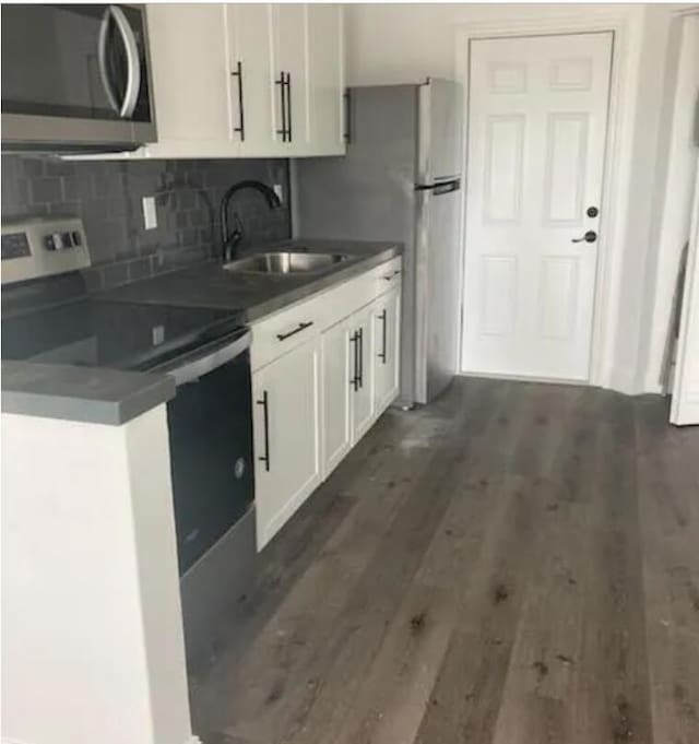 kitchen featuring white cabinetry, dark wood-type flooring, appliances with stainless steel finishes, and sink