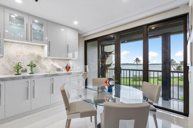 tiled dining area with a water view