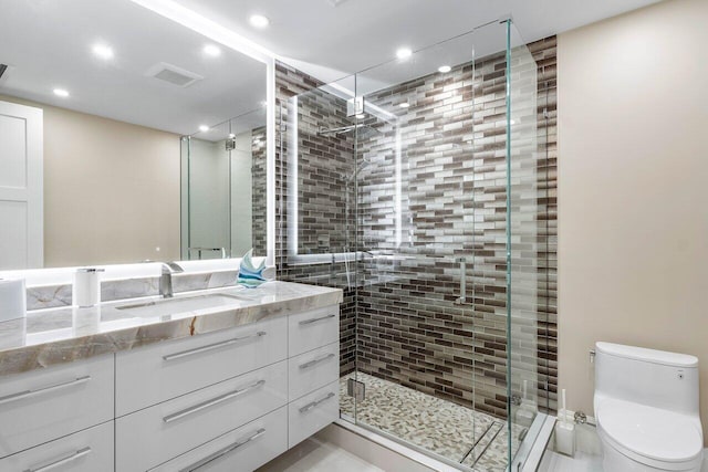 bathroom featuring a shower with door, tile flooring, toilet, and vanity