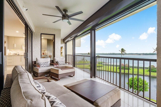 sunroom / solarium with ceiling fan and a water view