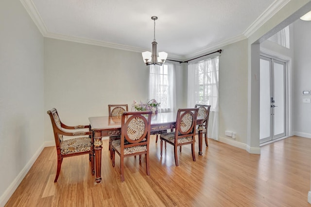 dining room with light hardwood / wood-style floors, crown molding, and a chandelier