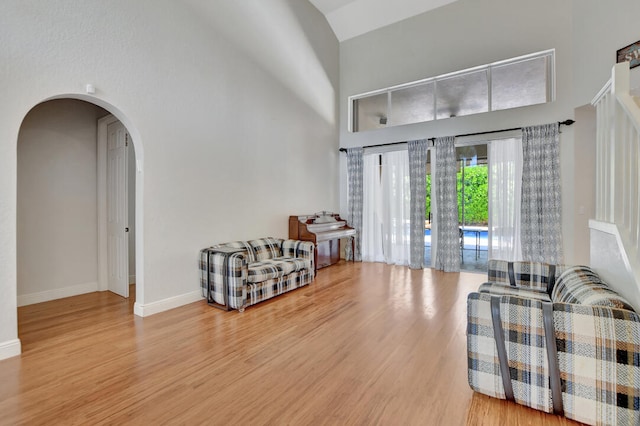 foyer with high vaulted ceiling and light hardwood / wood-style flooring