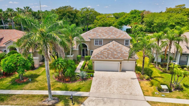 mediterranean / spanish home with a garage and a front yard