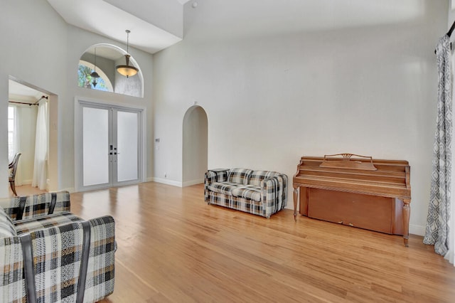 foyer entrance featuring a high ceiling, french doors, and light hardwood / wood-style flooring