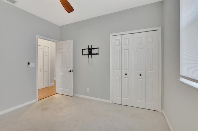 unfurnished bedroom featuring a closet, ceiling fan, and light colored carpet