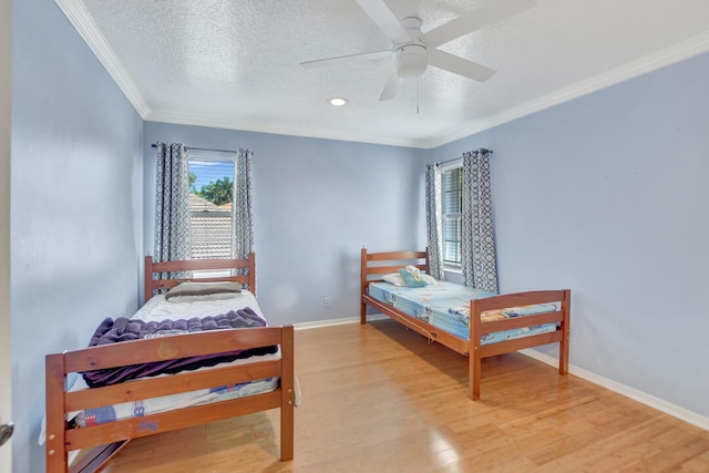 bedroom featuring crown molding, a textured ceiling, light wood-type flooring, and ceiling fan