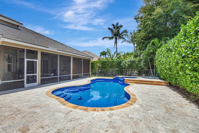 view of swimming pool featuring a sunroom and a patio area