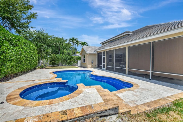 view of pool featuring a patio area, a sunroom, and an in ground hot tub