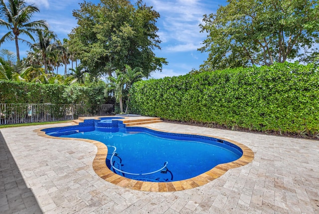 view of swimming pool featuring a patio and an in ground hot tub