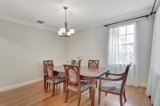 dining space featuring a notable chandelier, light hardwood / wood-style floors, and crown molding