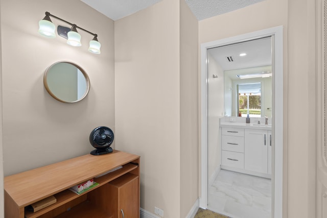 bathroom featuring tile flooring, vanity, and a textured ceiling