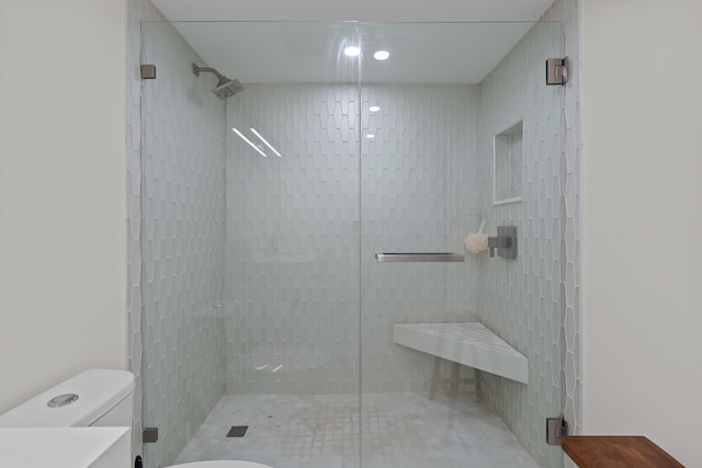 bathroom with tiled shower and toilet