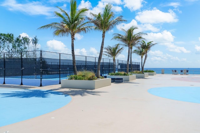 exterior space featuring a water view and tennis court