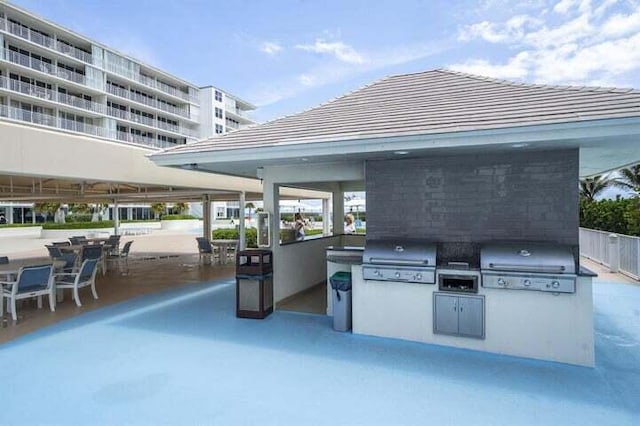 view of patio with an outdoor kitchen, a balcony, and area for grilling