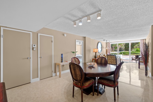 tiled dining room with track lighting and a textured ceiling