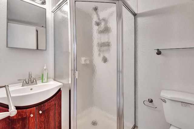 bathroom featuring vanity, toilet, and an enclosed shower