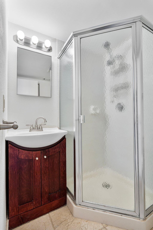 bathroom with vanity and a shower with door