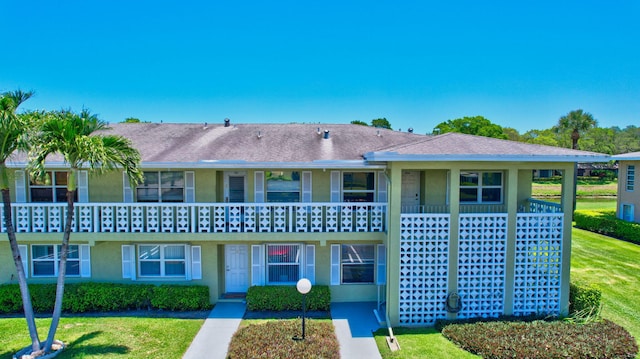 townhome / multi-family property featuring a front lawn