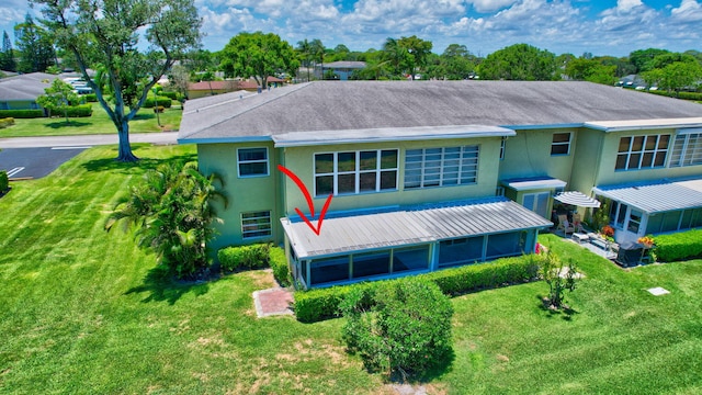 back of property with a sunroom