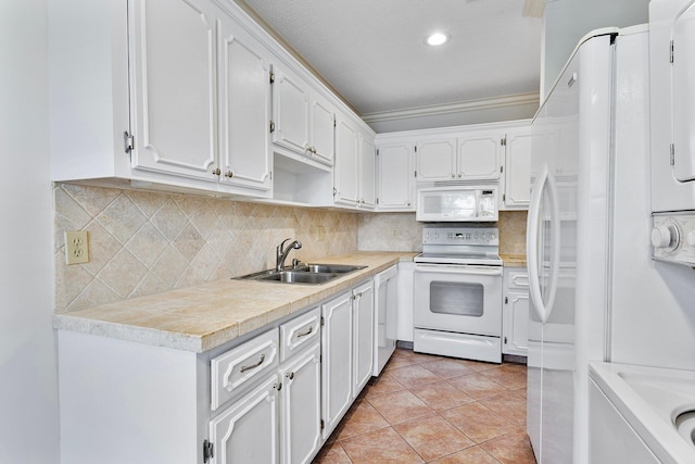 kitchen with light tile patterned flooring, sink, white cabinets, and white appliances