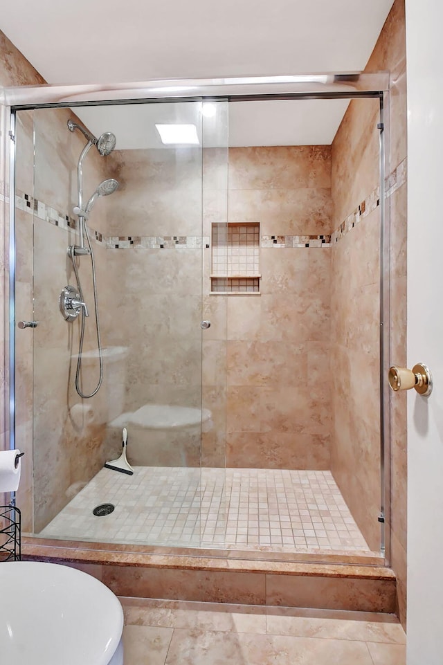 bathroom with tile patterned flooring, toilet, and a shower with door