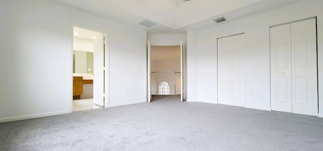 interior space featuring light carpet and ensuite bathroom