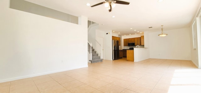 unfurnished living room featuring ceiling fan and light tile floors