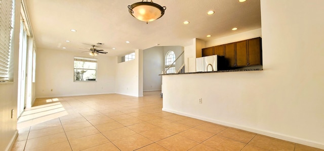 kitchen with a healthy amount of sunlight, hanging light fixtures, light tile floors, and stainless steel appliances