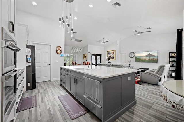 kitchen with ceiling fan, decorative light fixtures, sink, lofted ceiling, and white cabinetry