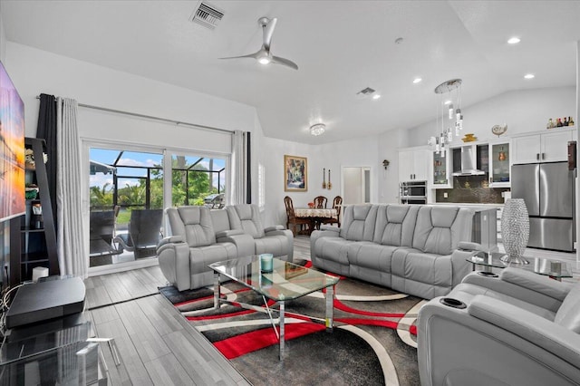 living room with lofted ceiling, ceiling fan, and hardwood / wood-style floors