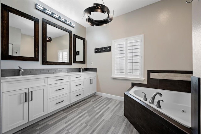 bathroom featuring dual sinks, tiled tub, and large vanity